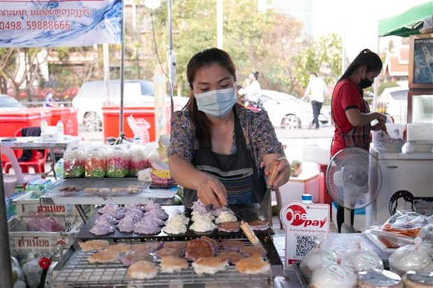 Người dân đeo khẩu trang phòng dịch COVID-19 tại hội chợ ẩm thực ở Vientiane, Lào. (Ảnh: THX/TTXVN)