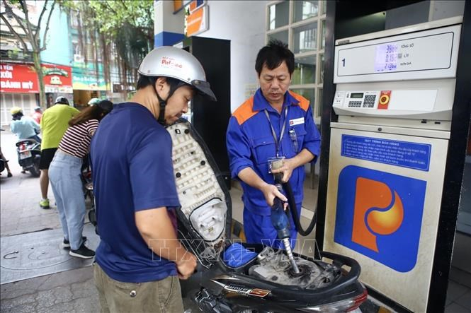 Nhân viên bán xăng cho khách tại cửa hàng xăng dầu Petrolimex. Ảnh: MInh Quyết-TTXVN